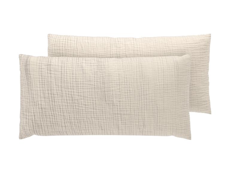Deux taies d'oreiller rectangulaires en mousseline de coton beige clair.