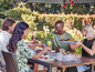 Des amis profitent d'un repas avec des légumes grillés et des salades en plein air.
