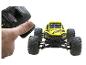 Télécommande à la main et voiture tout-terrain jouet jaune.