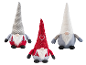 Trois gnomes décoratifs : un gris à pois, un rouge avec un cœur et un blanc pelucheux.