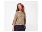 Femme en pull beige à manches courtes et pantalon foncé.