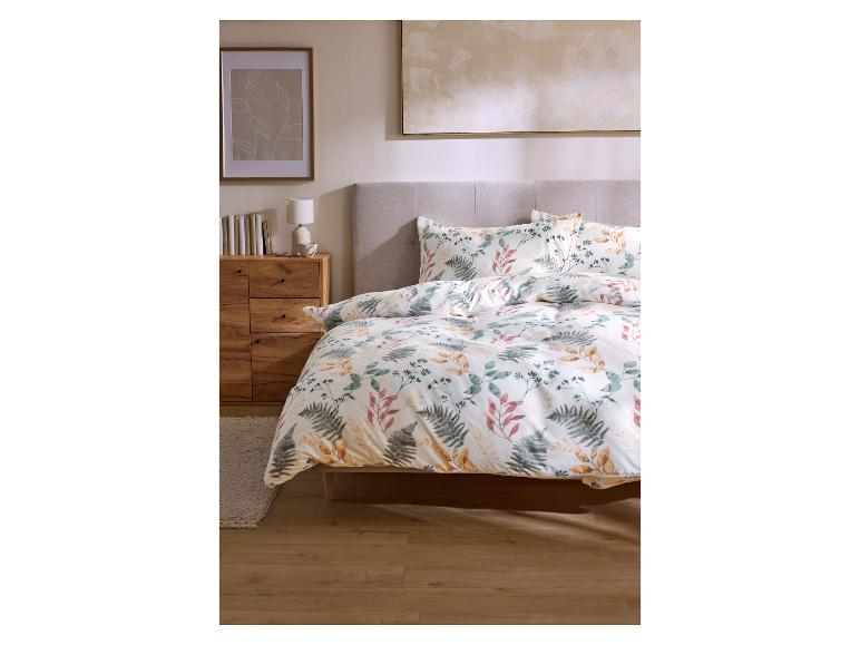 Chambre à coucher avec literie florale, table de chevet en bois et art mural