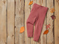 Leggings roses sur un fond en bois avec des feuilles d'automne