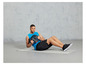 Un homme fait des exercices abdominaux avec un disque de poids de 5 kg sur un tapis.