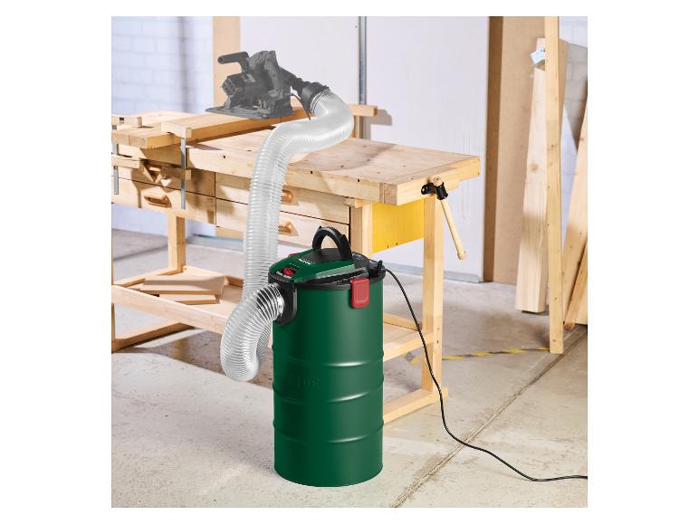 Aspirateur et tuyau avec scie circulaire sur un établi dans un atelier.