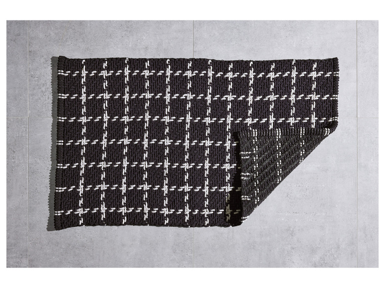 Un tapis tissé noir et blanc à motif à carreaux.