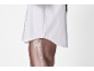 Chemise blanche et pantalon marron en similicuir.