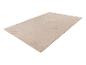 Tapis rectangulaire beige avec un motif subtil de rayures ondulées, vu en angle.