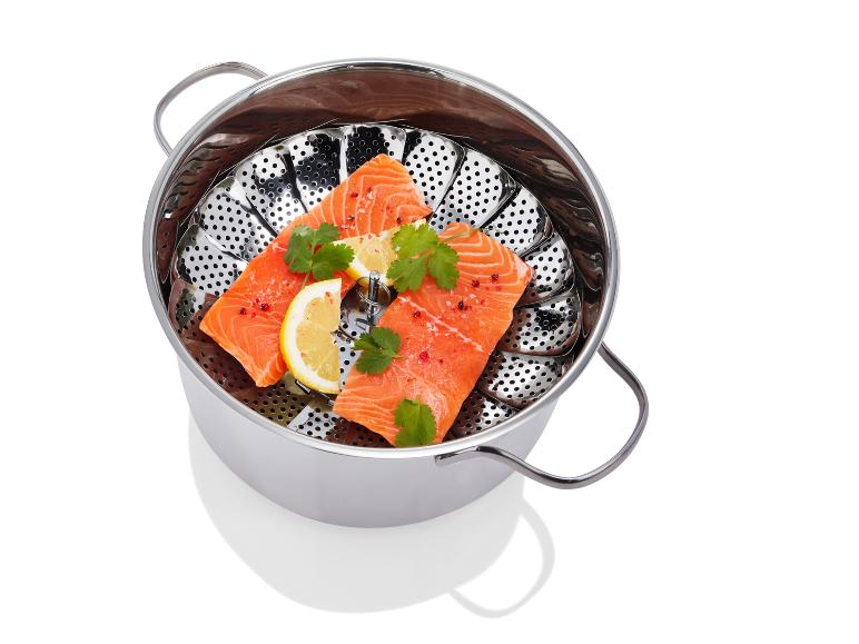 Une casserole vapeur en acier avec des filets de saumon, du citron et de la coriandre