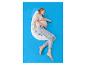 Femme enceinte dormant sur un oreiller de grossesse en forme de U sur un drap bleu.