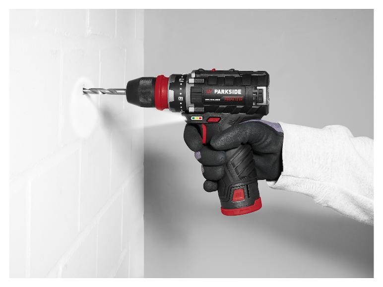 Une main gantée utilise une perceuse Parkside pour percer un mur blanc.