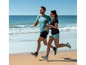 Un homme et une femme courent en vêtements de sport sur la plage.