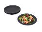 Assiettes noires avec une salade de fruits rouges, feta et germes.