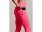 Une femme porte un legging rose avec un téléphone dans la poche.