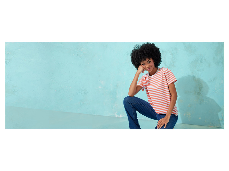 Une femme porte un t-shirt rayé et un jean.
