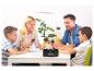 Une famille joue aux cartes avec un mélangeur de cartes automatique.