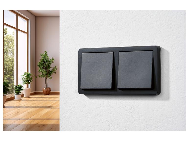 Deux interrupteurs noirs sur un mur blanc.
