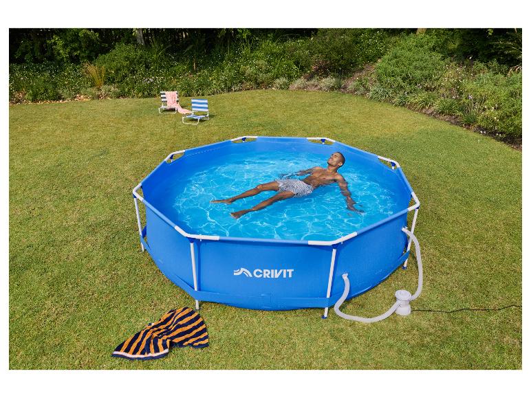 Homme se relaxant dans une piscine hors sol hexagonale bleue dans un jardin avec deux chaises de plage.