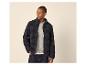 Homme en veste polaire foncée et pull clair, la main dans la poche.