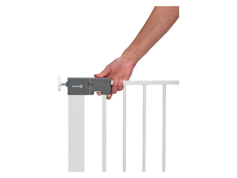 Main ouvrant une barrière de sécurité Safety 1st.