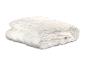 Une couette ou un édredon blanc matelassé, soigneusement plié et empilé sur un fond blanc.