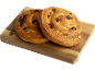 Deux escargots aux raisins dorés sur une planche en bois.