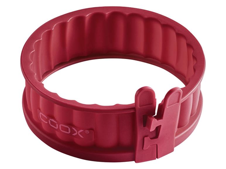 Un moule à pâtisserie en silicone rouge Cook, avec un diamètre réglable.