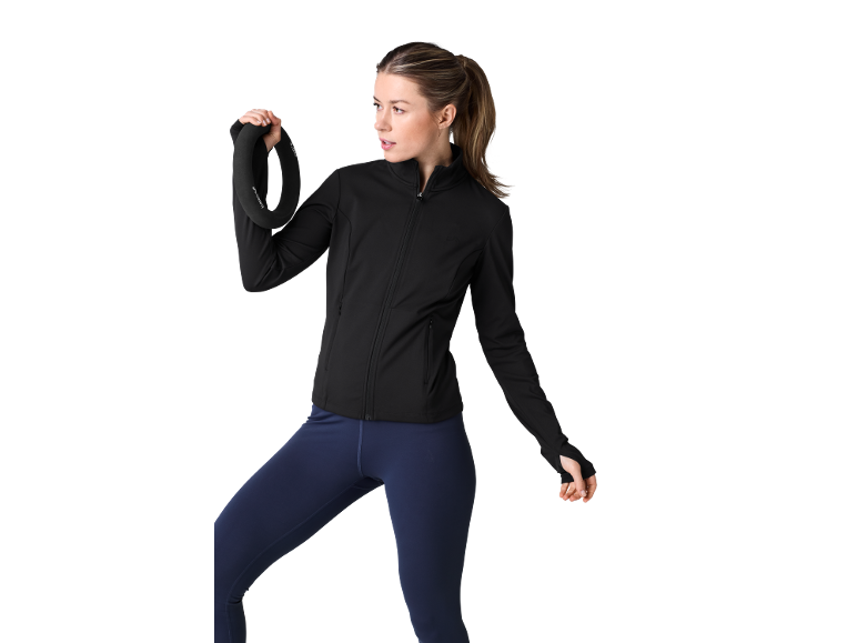 Femme en veste de sport noire et legging bleu tenant un poids en forme d'anneau.