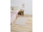 Un tapis beige dans une chambre à coucher avec une couverture rose sur un lit.