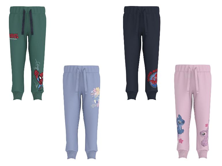 Quatre pantalons de survêtement pour enfants en vert, bleu, marine et rose avec divers imprimés de personnages.