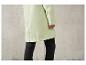 Un imperméable vert clair avec des leggings noirs.