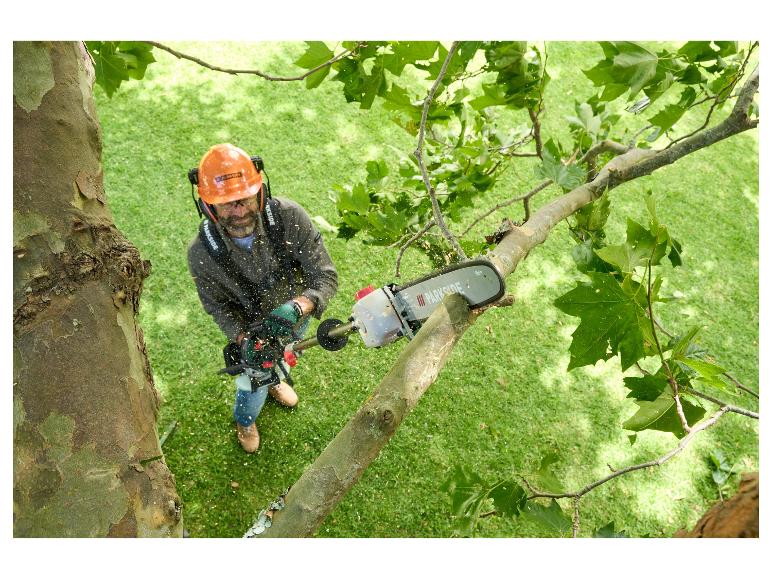 Un homme utilisant une tronçonneuse Parkside pour tailler un arbre.