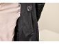 Intérieur d'une doudoune noire avec étiquette X-WARM et un t-shirt clair.
