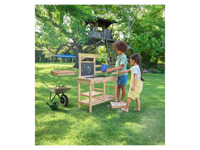 Enfants jouant dans le jardin avec la brouette et la table de jardinage LUPILU®.