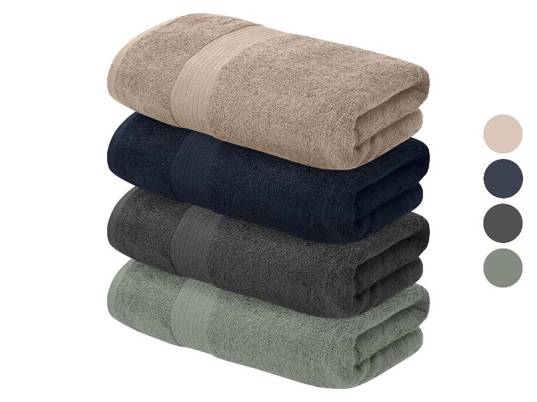 Une pile de quatre serviettes pliées aux couleurs neutres, avec des échantillons de couleur sur le côté.