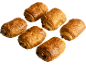 Six pains au chocolat dorés à la croûte croustillante, disposés sur fond noir.