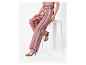 Modèle portant un pantalon rayé et des talons.