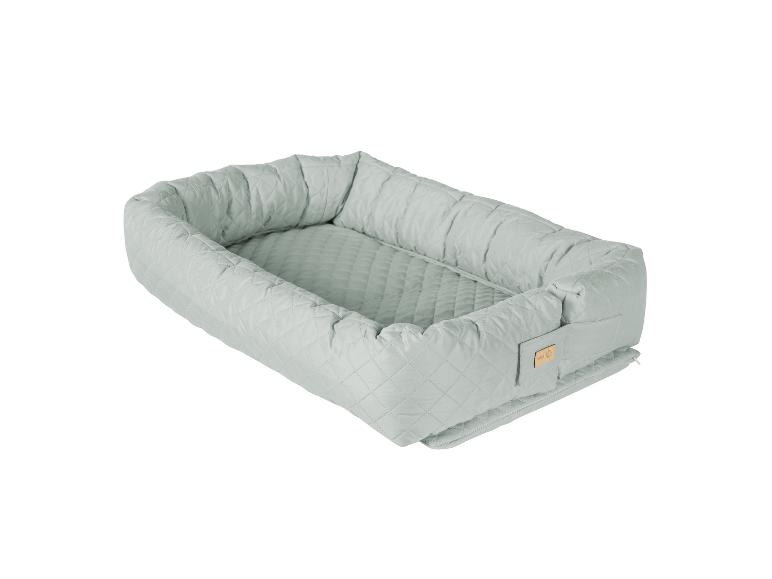 Nid de bébé matelassé vert clair avec motif en losanges.