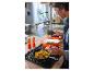Homme cuisinant avec la cocotte en fonte premium SILVERCREST® dans la cuisine.