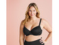 Une femme porte un soutien-gorge noir et un pantalon noir.