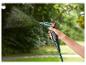 Une main tient un tuyau d'arrosage vert avec un pistolet d'arrosage de la marque Parkside.
