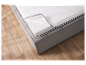 Matelas et sommier gris clair sur sol en bois.