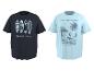 Deux t-shirts à manches courtes : un foncé avec des planches de surf et 'GOLDEN HOUR', et un bleu clair avec un surfeur, un palmier et 'RIDE THE WAVES CALIFORNIA'.