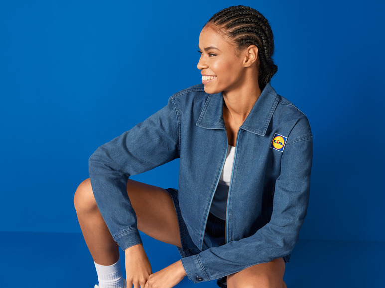 Une femme portant une veste en jean bleu avec le logo Lidl.