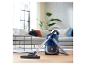 Un aspirateur Philips PowerGo bleu sur un sol en bois.