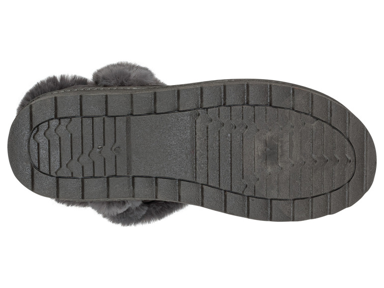 Le dessous d'une paire de pantoufles grises avec une semelle rugueuse.