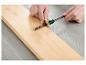 Une main utilise un outil circulaire en bois pour marquer une ligne sur une planche en bois.