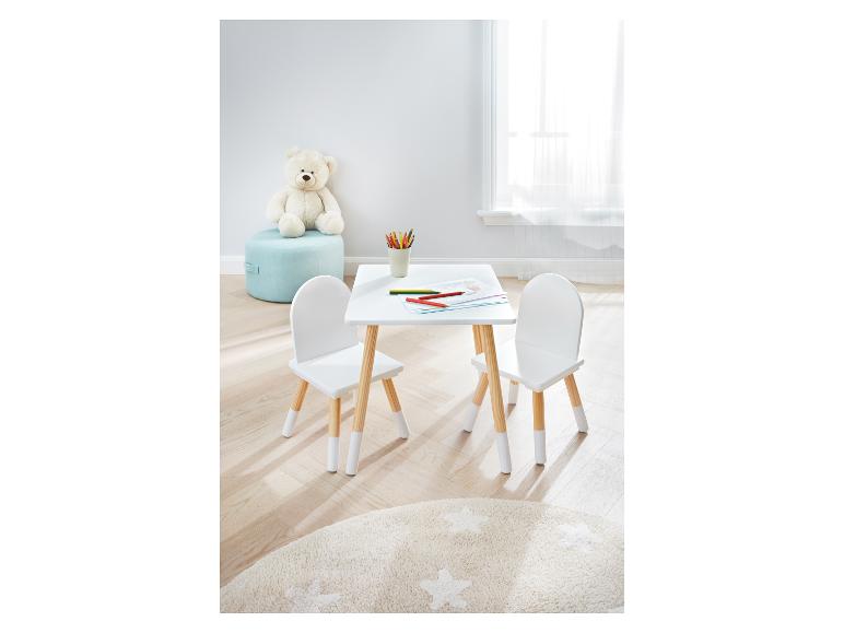 Une table et des chaises blanches pour enfants avec des pieds en bois.