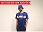 Homme en maillot de sport bleu et bob avec le texte 'VICTIME DE SON SUCCÈS'.