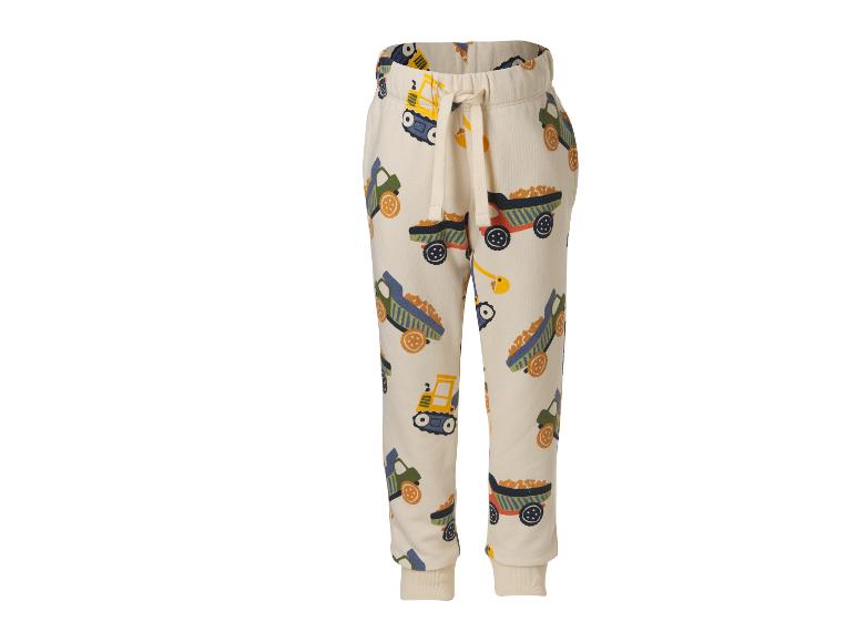 Pantalon de jogging beige pour enfant avec motif de véhicules de construction.